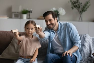 Mutlu baba ve kız çocuk video oyunu oynuyor.