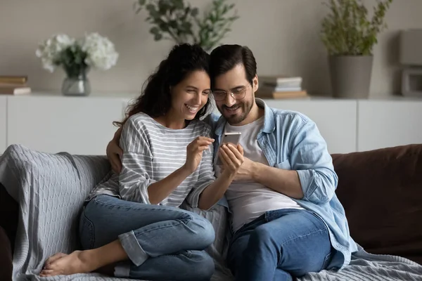 Feliz casal milenar usando aplicativo on-line no telefone móvel juntos — Fotografia de Stock