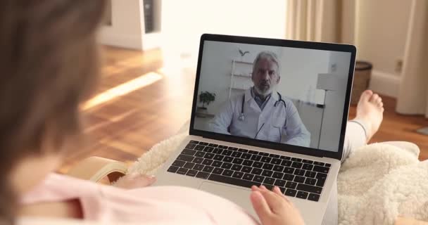 Jonge zwangere vrouw met videogesprek met oudere mannelijke verloskundige. — Stockvideo