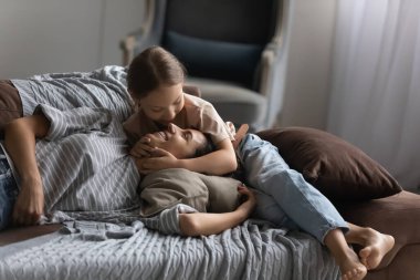 Sevimli mutlu çocuk sarılıyor ve annesine sarılıyor.