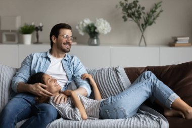 Mutlu milenyum çifti evdeki rahat koltukta dinleniyor.