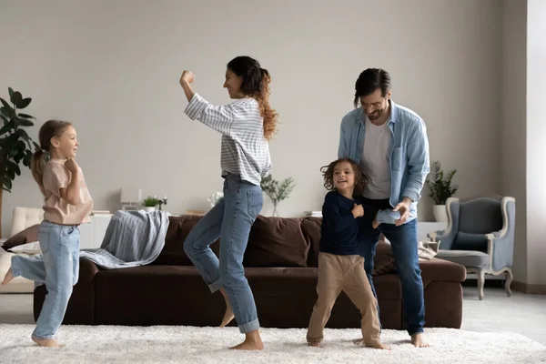 Nadšený šťastný rodinný tanec na hudbu v obývacím pokoji — Stock fotografie