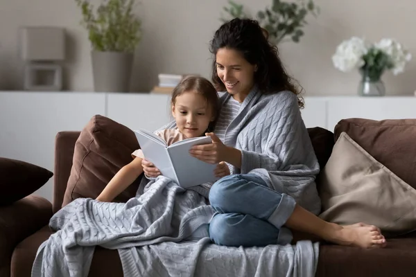 Feliz mamá e hija niño envuelto en un libro de lectura a cuadros — Foto de Stock