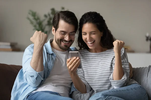 Συναρπαστικό οικογενειακό ζευγάρι που χρησιμοποιεί smartphone, κοιτάζοντας την οθόνη — Φωτογραφία Αρχείου