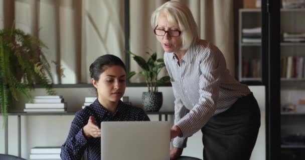 Mayor mentor ayuda a indio joven empleado con aplicación corporativa — Vídeo de stock