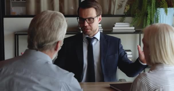 Los cónyuges mayores felices reciben la consulta profesional de la aseguradora durante la reunión — Vídeo de stock