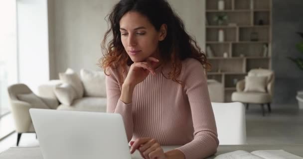 Leende ung latinkvinna frilansare arbetar vid datorn. — Stockvideo