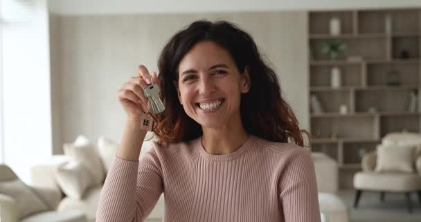 Boldog millenniumi latin női lakástulajdonos mutatja kulcsok kamera. — Stock videók