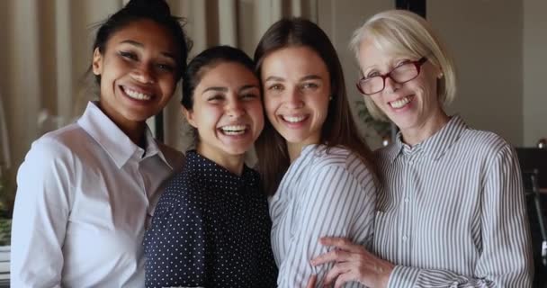 Gelukkig multiraciale vrouwen in formele kleding staan indoor knuffelen en lachen — Stockvideo