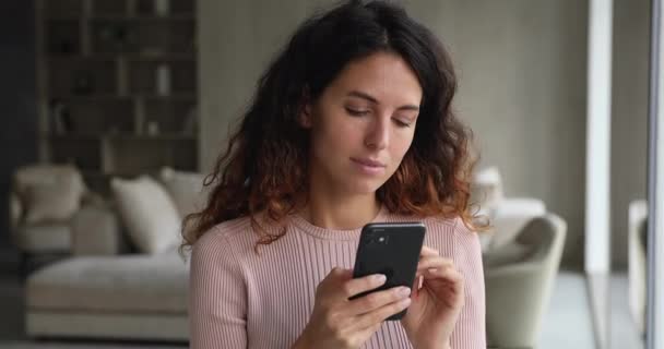 Glad drömmande ung latinamerikansk kvinna som använder mobila mjukvaruapplikationer. — Stockvideo