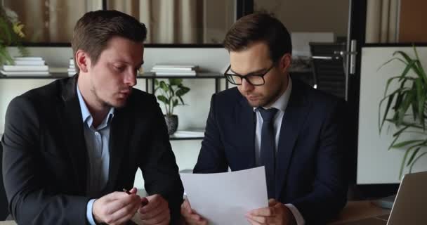 Два бизнесмена встречаются в офисе для обсуждения контрактов — стоковое видео