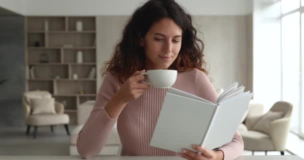 Gelukkige jonge Spaanse vrouw die boek leest, thee drinkt. — Stockvideo