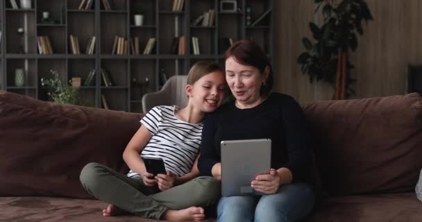 Heureuse famille multigénérationnelle utilisant différents gadgets. — Video