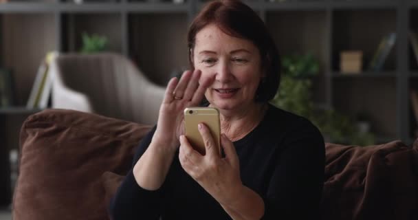 Heureuse femme d'âge moyen tenant conversation mobile appel vidéo. — Video