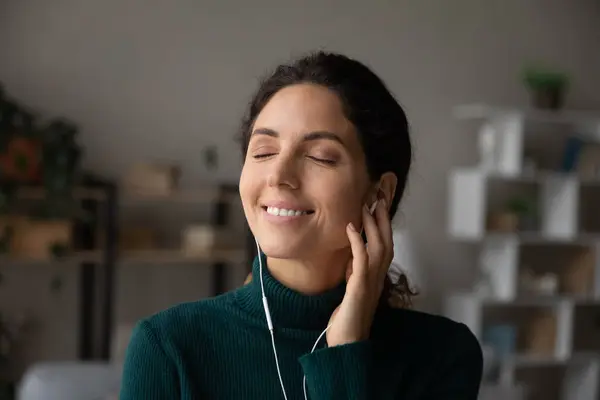 Tête tournée femme souriante appréciant la musique préférée avec les yeux fermés — Photo