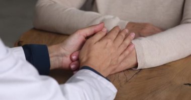 Nazik empatik genç bayan doktor yaşlı hastayı destekliyor..