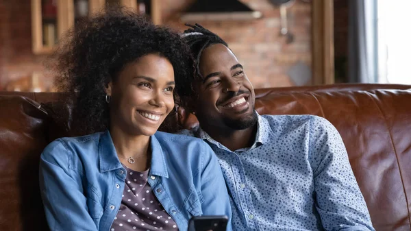 Feliz pareja étnica descansan en sofá soñando visualizando — Foto de Stock