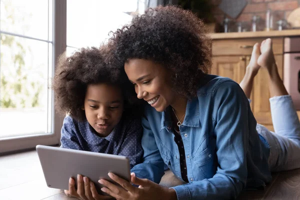 Happy ethnic mom and daughter use tablet together — Stock Photo, Image