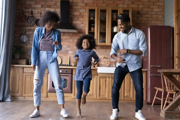 Famille ethnique excitée avec enfant danser ensemble dans la cuisine — Photo