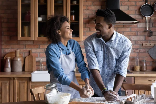 Sonriente pareja birracial cocinar juntos en casa cocina —  Fotos de Stock