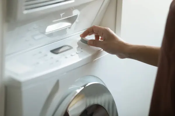 Close up of woman turn on modern washing machine — Stock Photo, Image