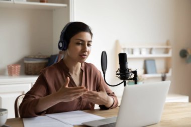 Hintli kadın video konuşmasında mikrofon kullanıyor.