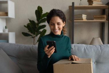 Telefonu kullanan kadını kapat, internetten siparişleri kontrol et, kutuları aç