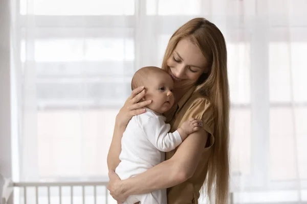 Sorrindo jovem mãe segurar nos braços bebê bebê — Fotografia de Stock