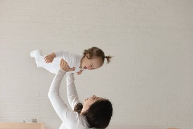 Sevgi dolu mutlu anne tatlı kızıyla oynuyor.