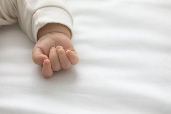Primer plano del puño del bebé recién nacido en la cama —  Fotos de Stock
