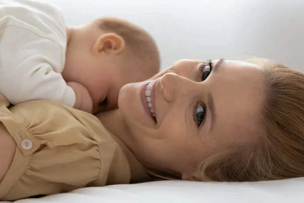 Gülümseyen anne ve yeni doğmuş bebeğin yakın portresi. — Stok fotoğraf
