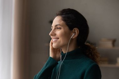 Müzik dinleyen gülümseyen rüya gibi kadının profilini kapat.