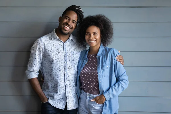 Retrato de feliz pareja étnica abrazo en la pared de fondo — Foto de Stock