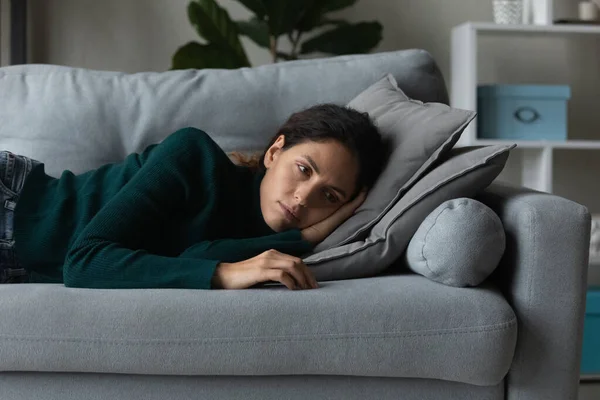 Close up frustrated woman lying on couch alone, feeling depressed — Stock Photo, Image