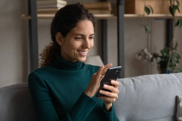 Close up happy young woman using smartphone, relaxing on couch — Stock Photo, Image