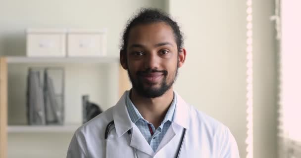 Médico médico general africano en uniforme sonrisa mira la cámara — Vídeo de stock