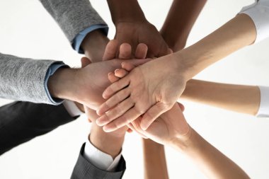 Close up of diverse people stack hands for shared success clipart