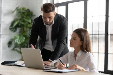 Çeşitli iş adamları ofisteki laptopta beyin fırtınası yapıyorlar.