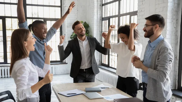 Empleados multirraciales emocionados celebran victoria compartida — Foto de Stock