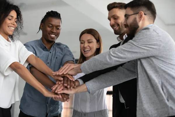 Heyecanlı çeşitli çalışanlar el ele tutuşup başarıyı kutluyor