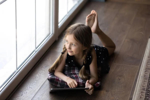 Gelukkig doordachte gen Z kind rustend op verwarmingsvloer — Stockfoto