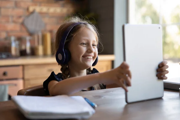 Gelukkige opgewonden school leerling kind het dragen van een koptelefoon, met behulp van tablet — Stockfoto