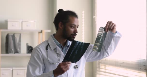 Médecin radiologue africain examinant un film radiographique à l'hôpital — Video