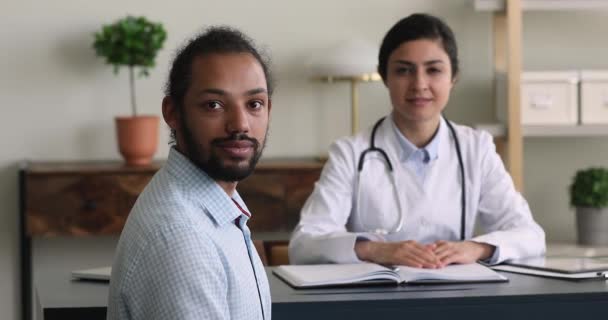 Africano etnia clínica paciente e confiável indiano médico retrato — Vídeo de Stock