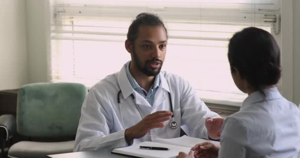 Médico africano consultando paciente indiano sobre tratamento de doenças — Vídeo de Stock