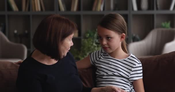 Fürsorgliche ältere Oma im Gespräch mit kleinem Enkelkind. — Stockvideo