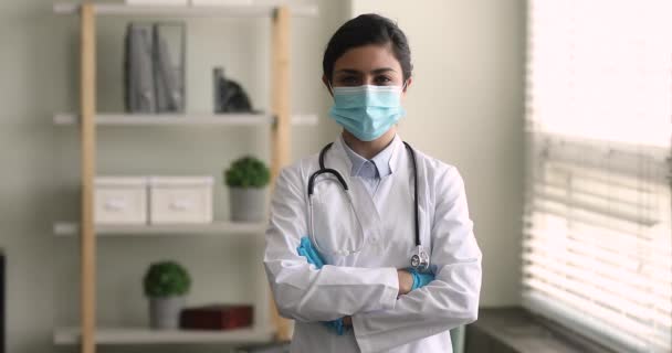 Indický lékař nosit plášť maska stojí uvnitř se zkříženýma rukama — Stock video