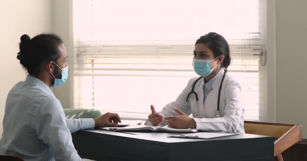 印度治疗师非洲病人在探访期间佩戴外科面罩交谈 — 图库视频影像