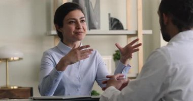 Hintli hasta Afrikalı doktorla konuşuyor. Klinikte oturuyor.