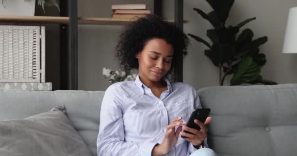 Mosolygó vonzó millenniumi afro-amerikai nő a mobiltelefon. — Stock videók